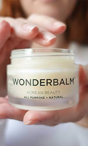 Jar of WONDERBALM held by hands close-up