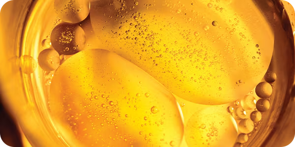 Close-up of olive oil, jojoba oil liquid with bubbles 