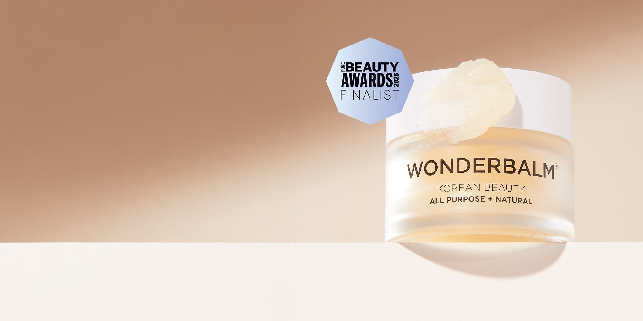 Wonderbalm jar with 'Beauty Awards' finalist badge on a gradient background